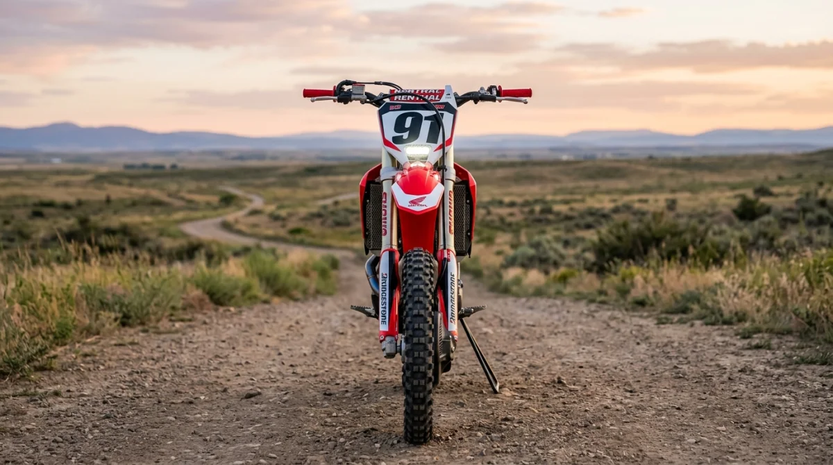 Moto de cross moderne à l'arrêt dans un paysage naturel, illustrant la pratique du sport en moto.